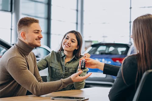 Happy family with new car keys at a dealership